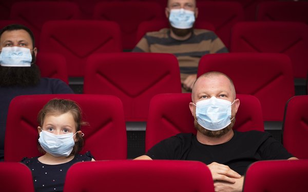 Tochter und Vater mit Mund Nasen Schutz im Theater